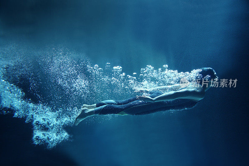 女性游泳者在水下流动的蓝色背景