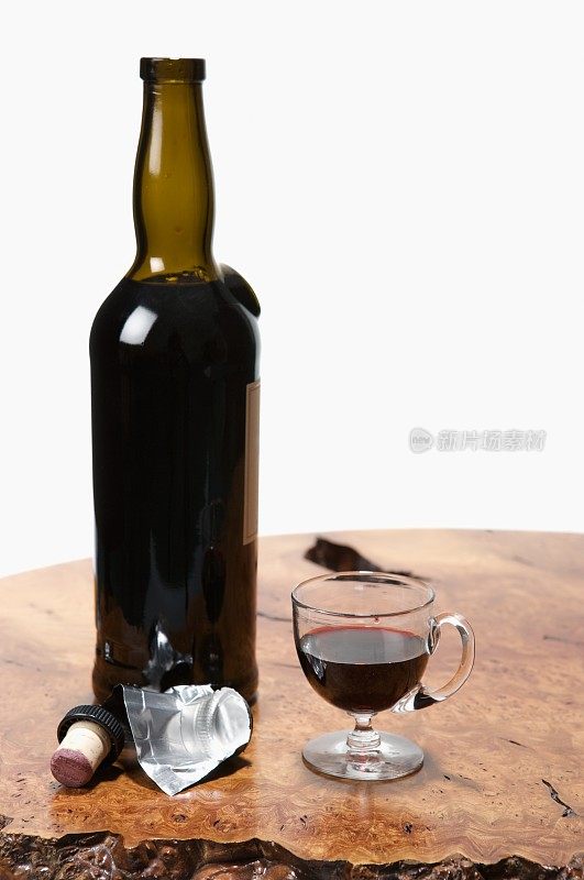 木桌上刚开了一瓶葡萄酒和玻璃杯