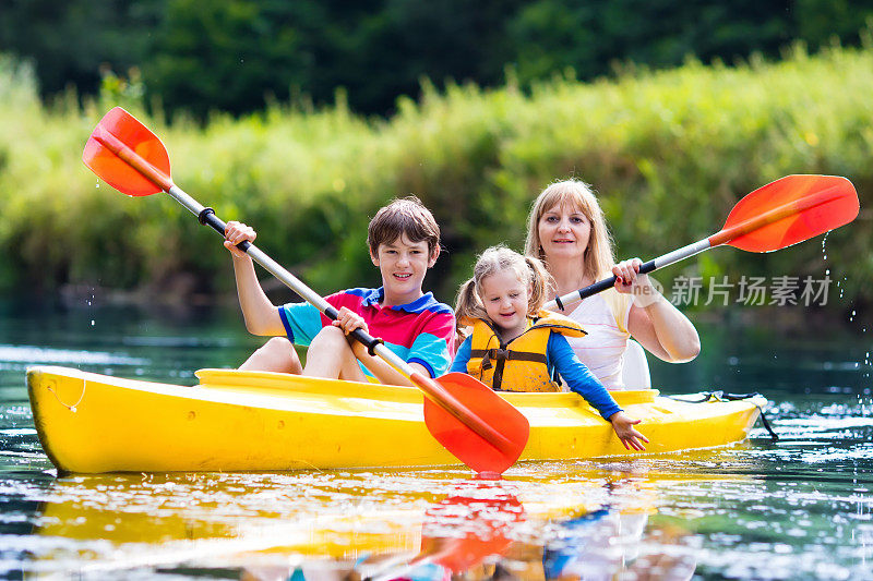 一家人在美丽的河流上享受皮划艇