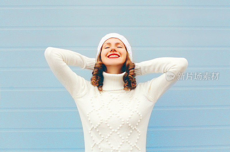 快乐微笑的女人享受好日子戴着编织的帽子，毛衣