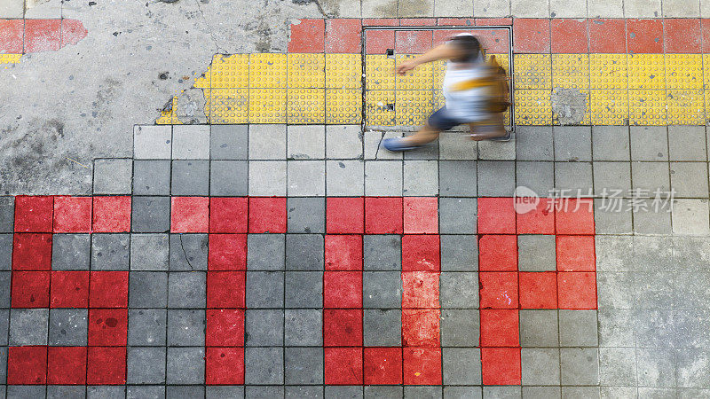 鸟瞰图和俯视图模糊的人是行走在商业区的行人和红色和黄色街区的人行道