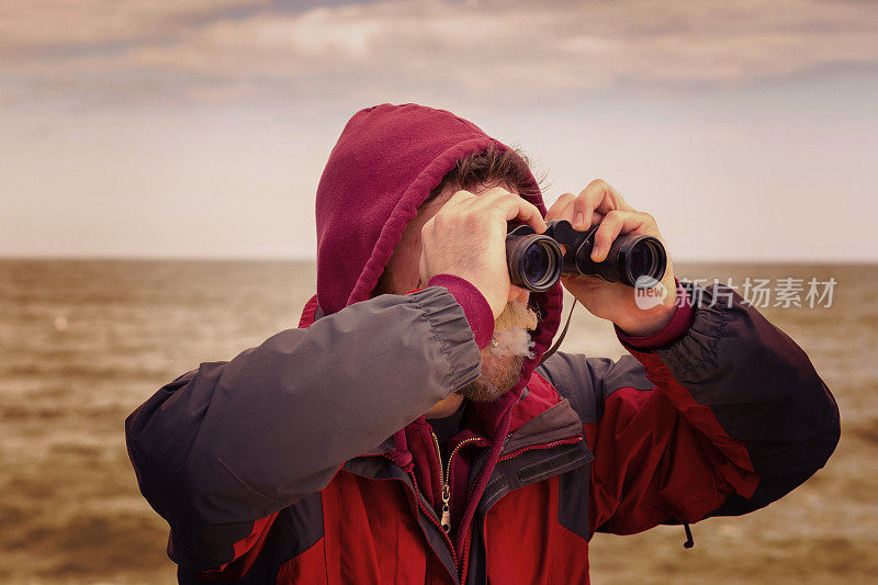 渔夫用双筒望远镜看海