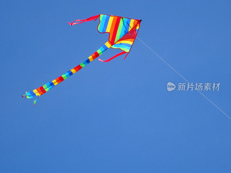 风筝的形象与彩虹条纹飞在蓝天