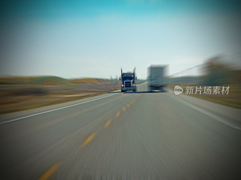 一辆卡车驶下高速公路，经过另一辆带有放大效果的卡车