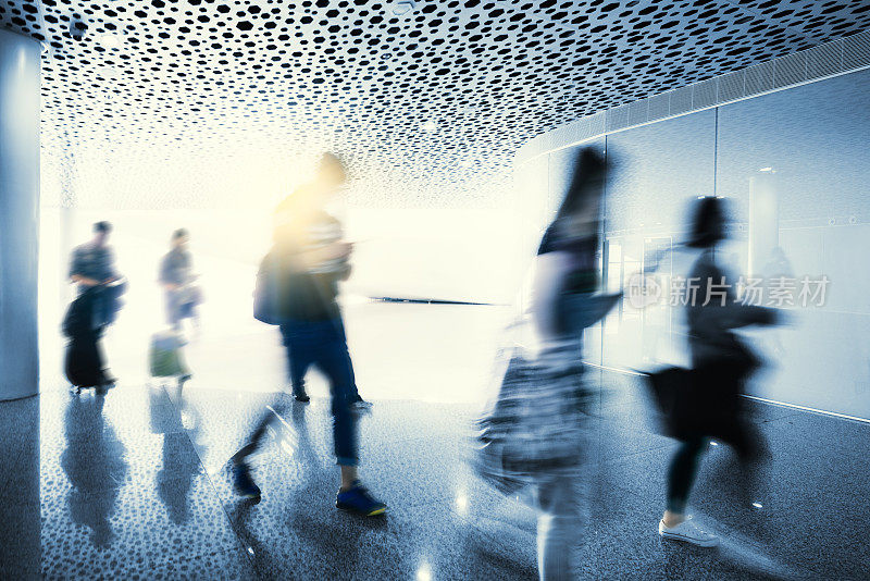 游客们走在现代化的机场走廊上