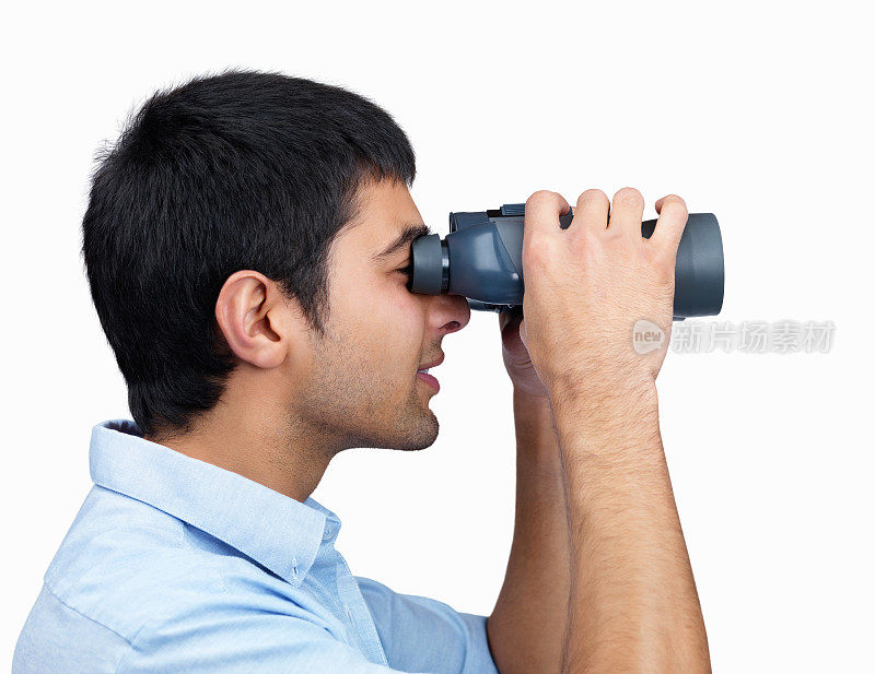 一个人用双筒望远镜寻找东西的侧面图
