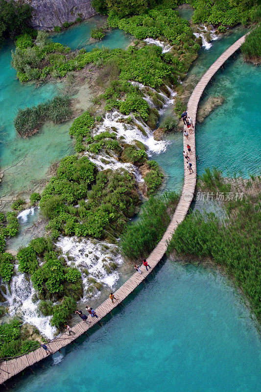 人们走在Plitvice湖上的人行桥上