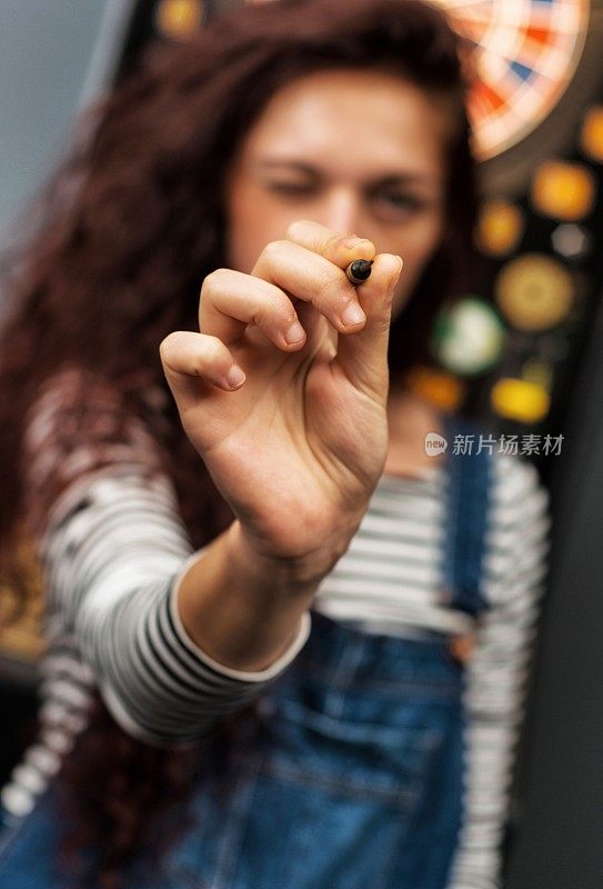 年轻女子在酒吧玩飞镖