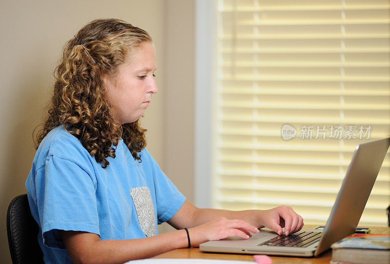 女孩在窗边的桌子上用电脑