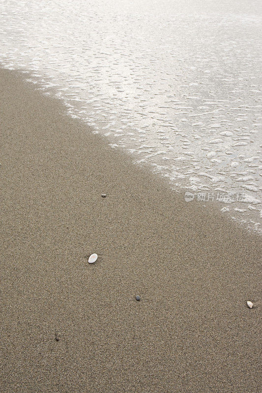 海岸线，泡沫和白色的卵石