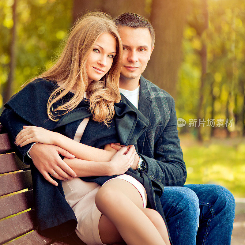 幸福的年轻夫妇在秋天的公园