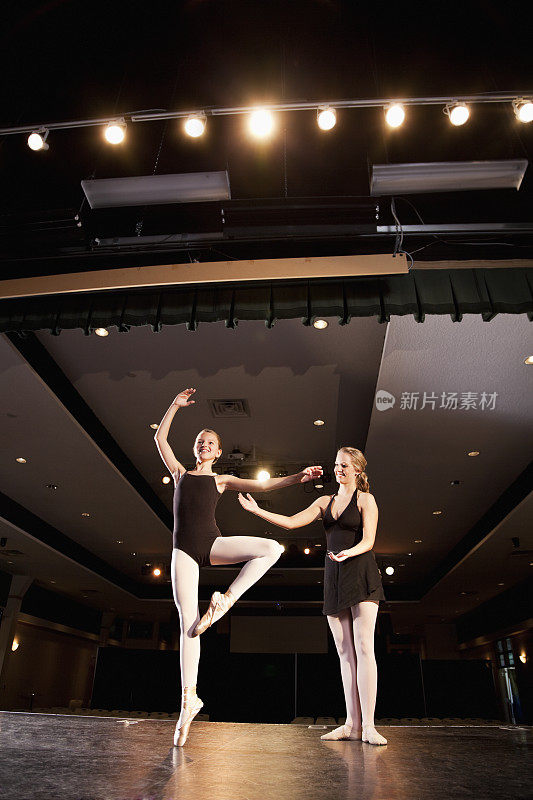 舞蹈教练在舞台上帮助芭蕾舞者