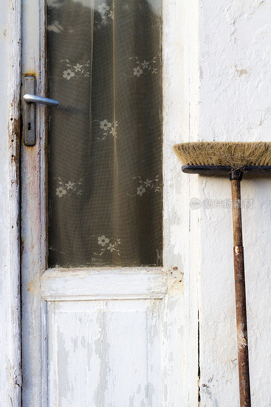 意大利，迷人的白色老门口，带花边窗帘和扫帚