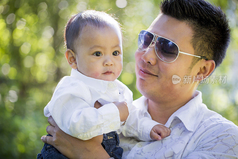 一位菲律宾父亲在公园里抱着他的小儿子。