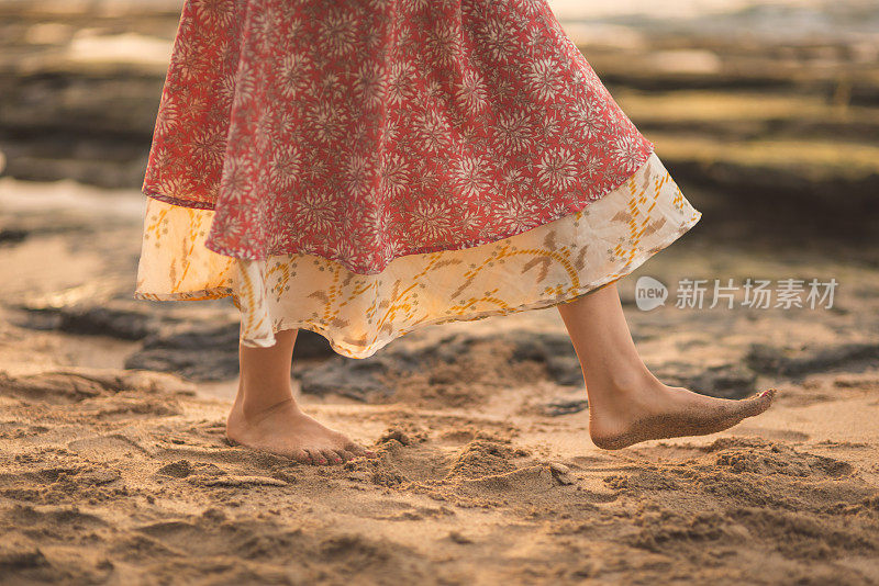 美丽的欧亚女人旋转在夏威夷海滩上日落接近