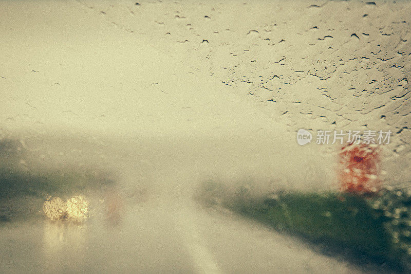 在一个非常下雨的日子里，在新布伦瑞克的道路上行驶的汽车挡风玻璃的特写。