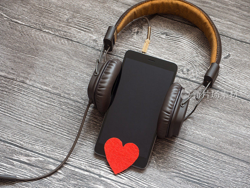 耳机挂在智能手机上，而智能手机就是心脏。象征着对音乐的热爱