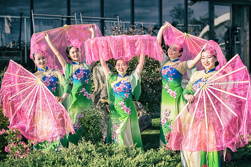 五名亚洲女演员身着中国传统服装，与粉丝们在户外