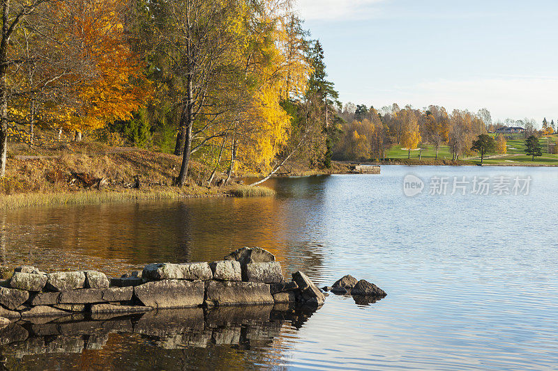 秋天的一个阳光明媚的日子，湖边有一个古老的石头码头。