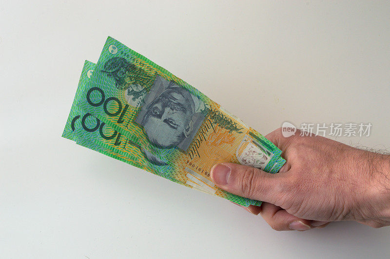 一个手里拿着300澳元钞票的人