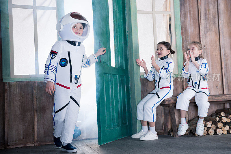 孩子们穿着宇航员服装，女孩们为男孩鼓掌