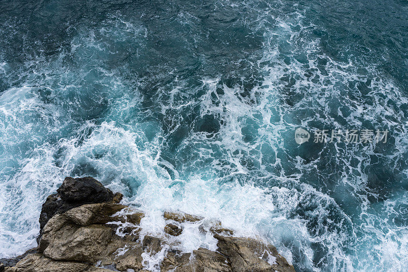意大利波西塔诺秋季暴风雨来临前，危险的海浪拍打着岩石海岸，溅起浪花和泡沫