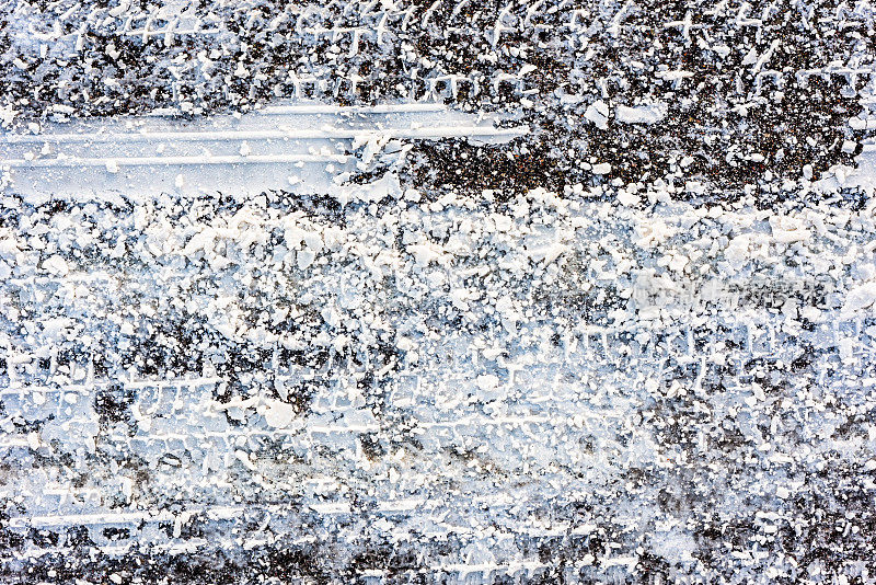 冬天的路面纹理，沥青覆盖的雪和轮胎痕迹