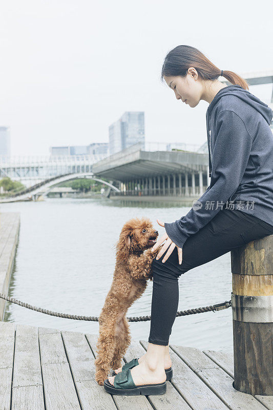 一个女人和她的小狗在河边玩