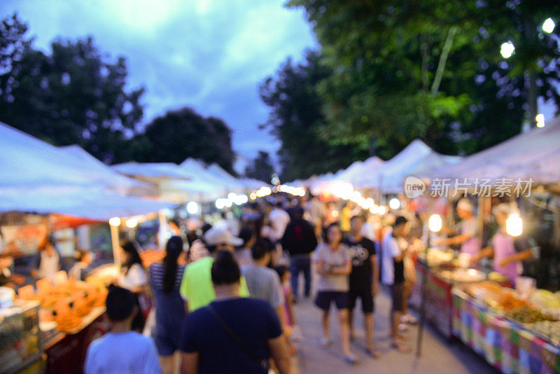 模糊背景的步行街市场在泰国曼谷。游客周末在当地市场购物