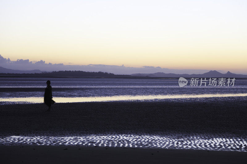 在昆士兰日落后的海滩上散步