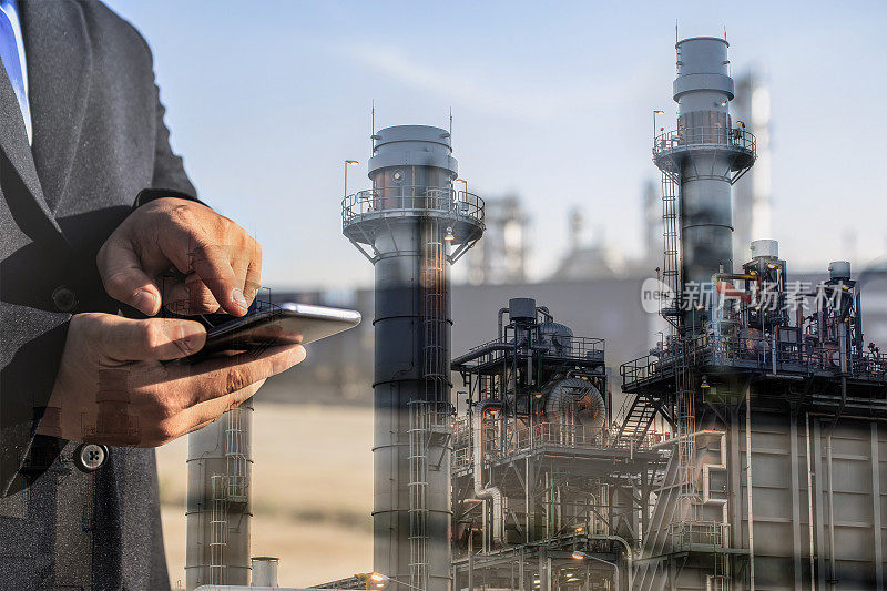 商人用智能手机检查炼油厂工厂的双重曝光