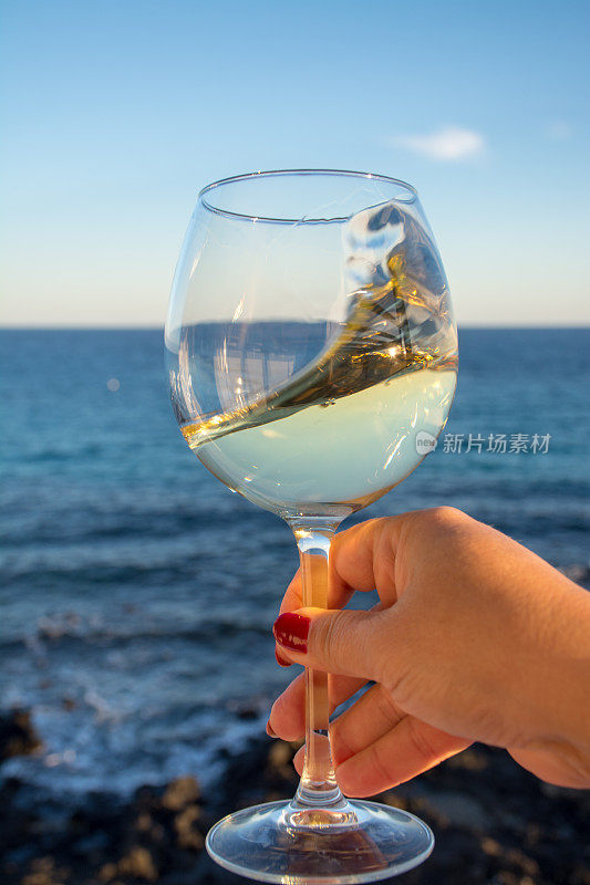 在室外阳台上品尝一杯冰凉的白葡萄酒