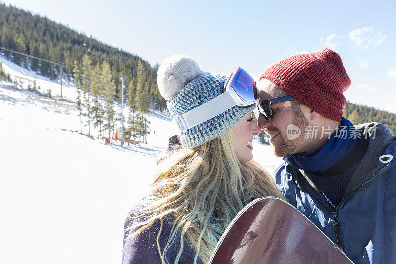 年轻夫妇在滑雪坡上给爱斯基摩人的吻
