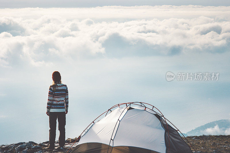 女人在山崖独自雾云景观的背景旅行生活概念冒险度假户外帐篷露营