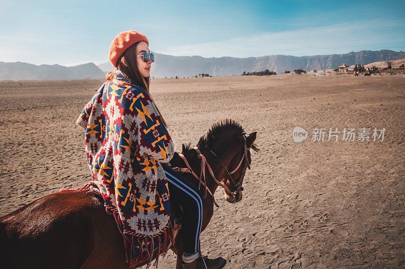 旅行者妇女在印度尼西亚的Bromo山骑马