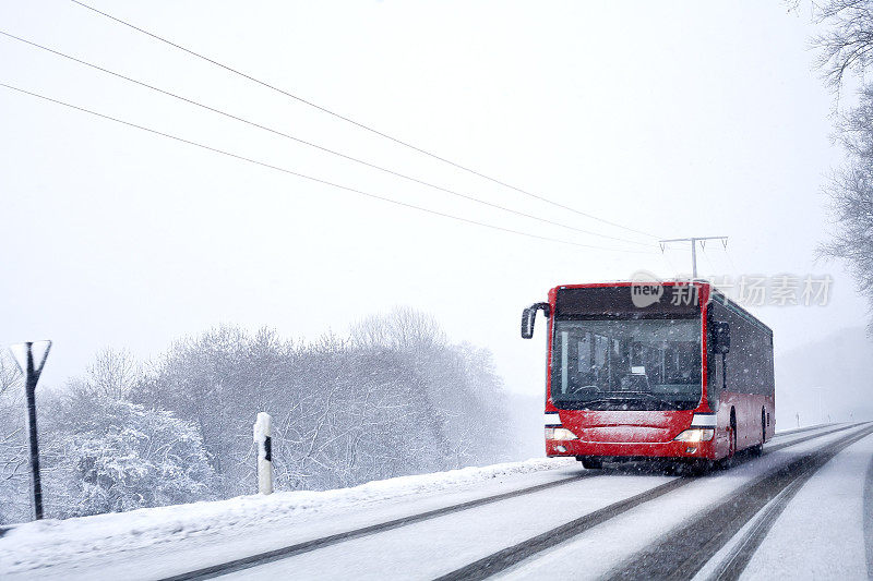 公交车在冬天的路上，下着大雪