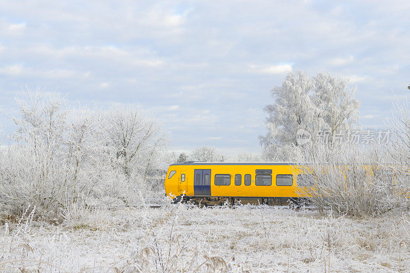 荷兰铁路的火车驶过一片冰冻的冬季景色