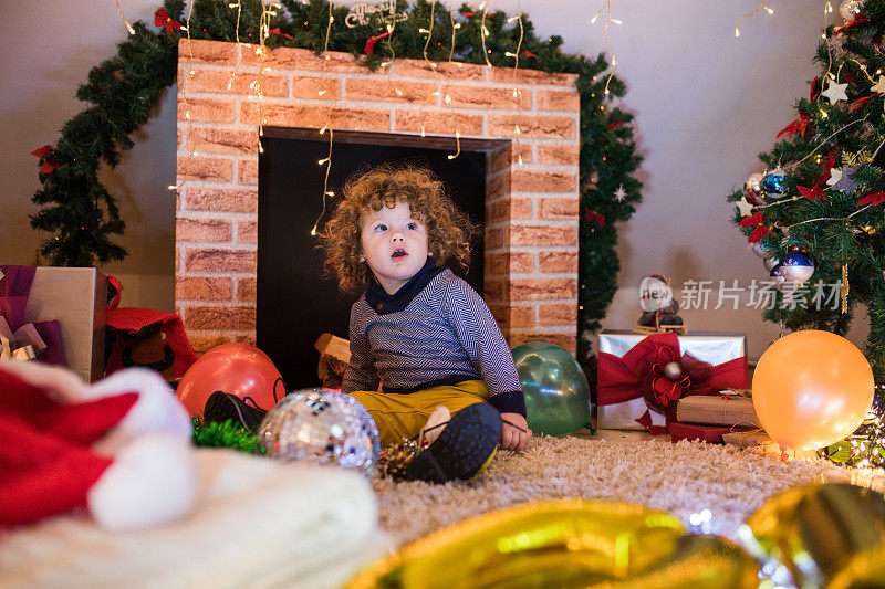 孩子在圣诞树和壁炉在圣诞夜。