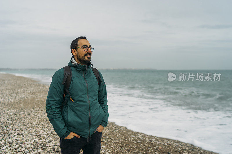 下雨天在海滩上散步的人