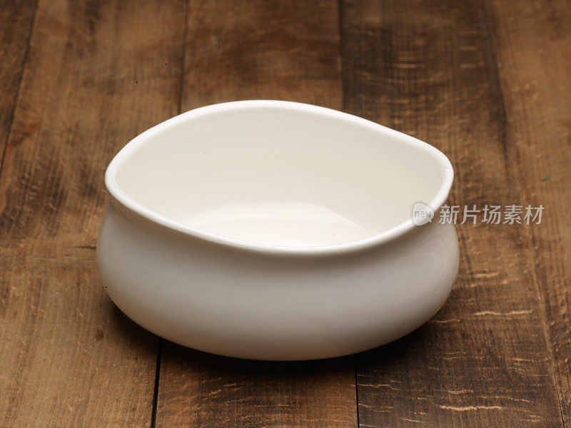 木质背景上的空白瓷碗。