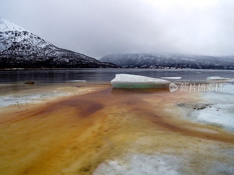 冰山漂浮在峡湾橙色的水面上