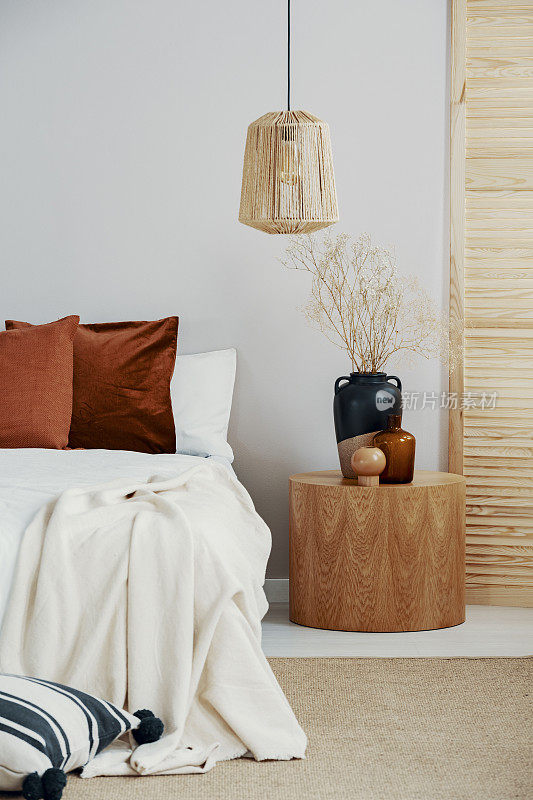 斯堪的纳维亚风格的柳条吊灯在优雅的卧室室内