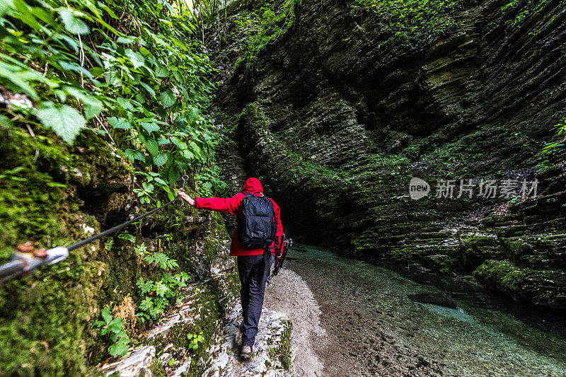 在斯洛文尼亚科巴里德附近的朱利安阿尔卑斯峡谷中，人们正在探索令人惊叹的科兹雅克瀑布的路径