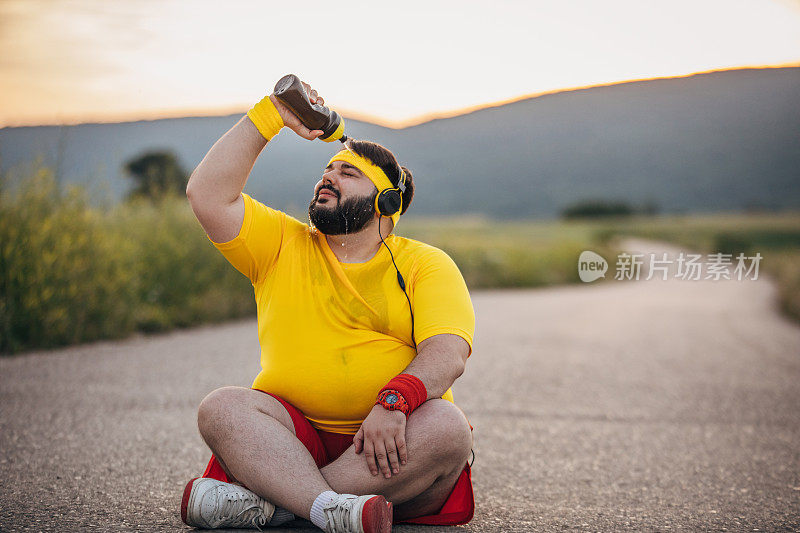 一个超重的男人往他脸上泼水