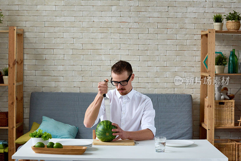 年轻的素食者正在切西瓜