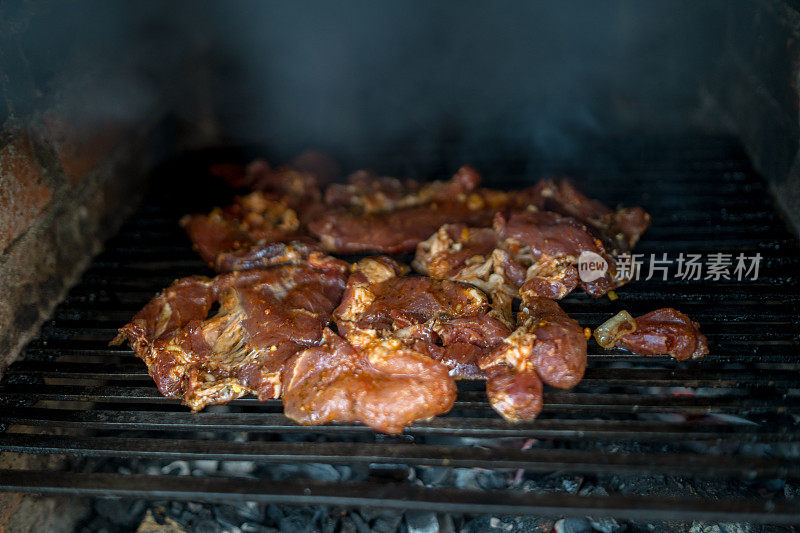 烤架上烤五花肉，烹饪活动。