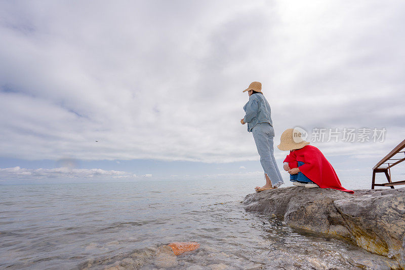 两姐妹在湖边喂鱼