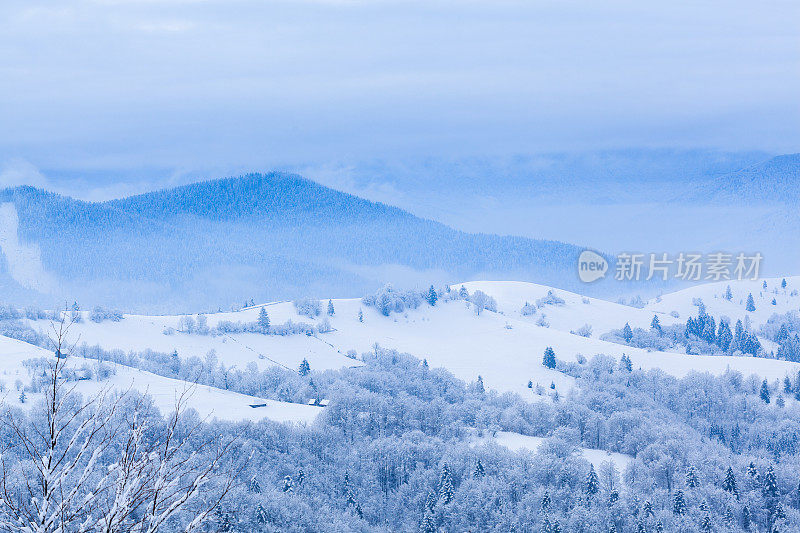 山峰上的雪被风吹走了。冬天的风景。天很冷，下着雪。