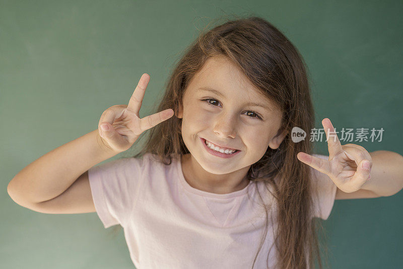 7岁可爱的小女孩肖像在绿色的背景