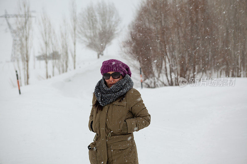 在雪中穿着暖和的衣服和贝雷帽的成年妇女肖像